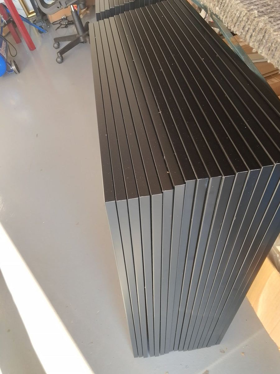 Black frame mouldings stacked in the studio